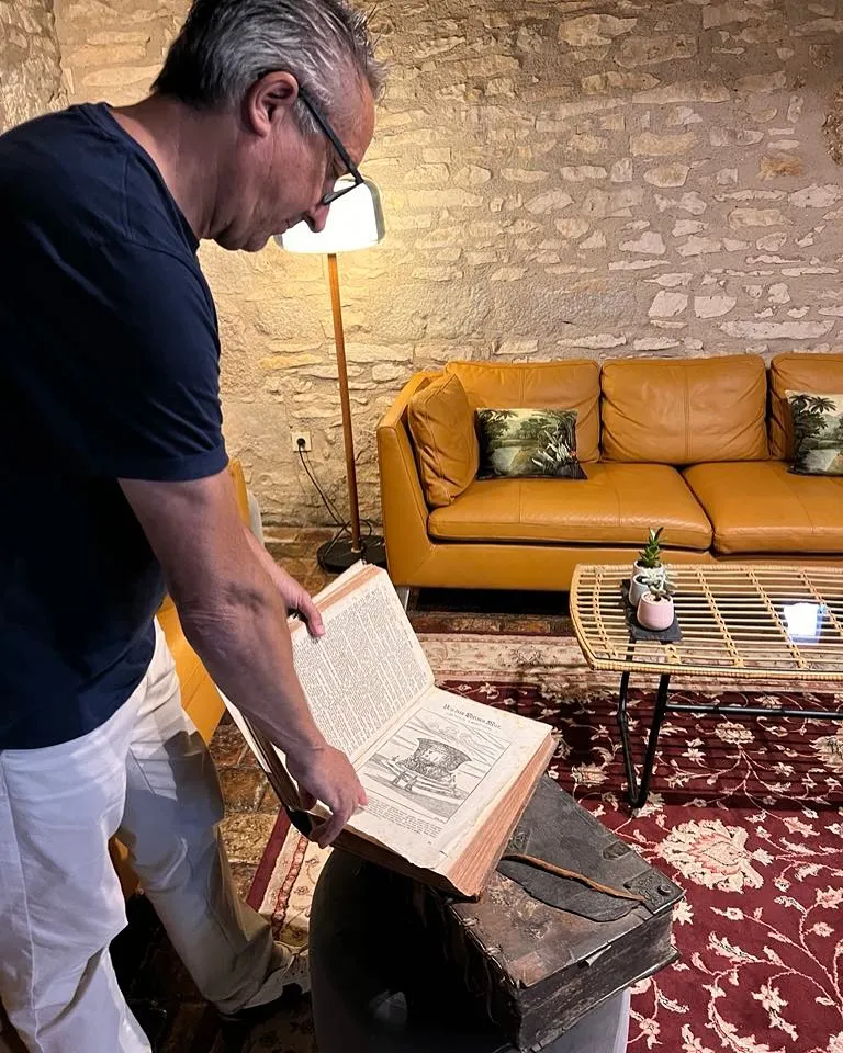 Salon avec livre ancien mur en pierre authentique