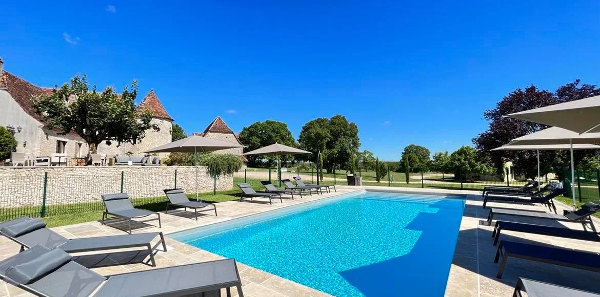 Piscine chauffée avec transats et vue sur l'hôtel Les Vieilles Tours - Rocamadour